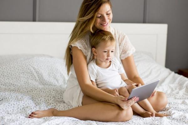 Mom Reading Bedtime Story to Toddler in Bed