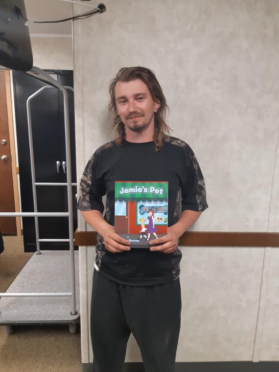 Ryan Frost Takes A Picture Holding Jamie's Pet Children's Book
