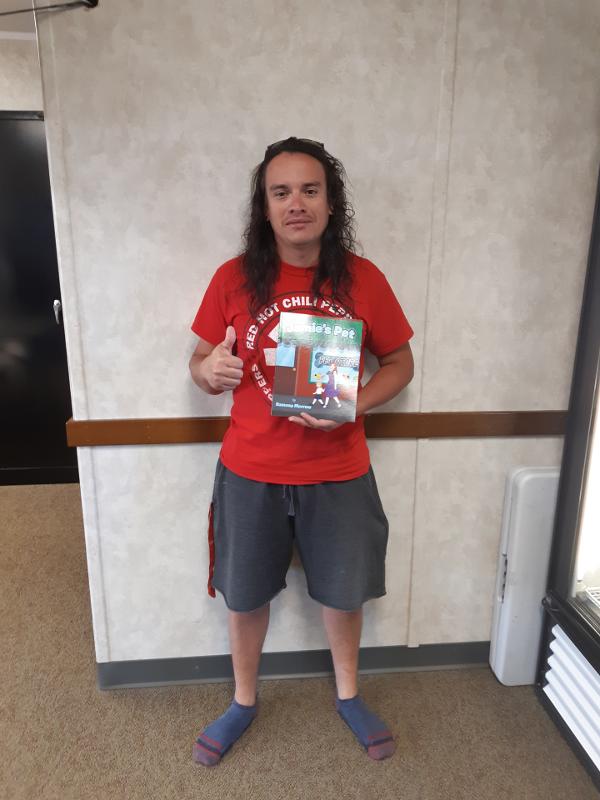 Abner Sanchez Holding A Copy Of Jamie's Pet Children's Book